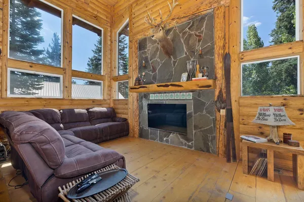 a living room with furniture a floor to ceiling window and a fireplace