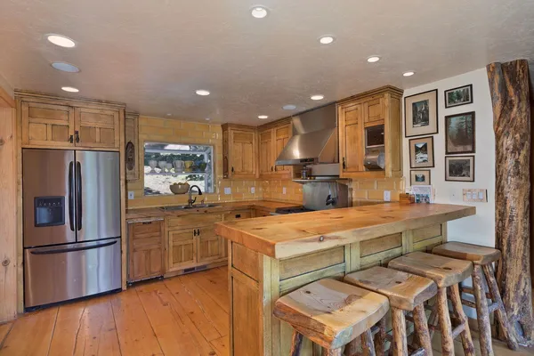 a kitchen with stainless steel appliances granite countertop a sink refrigerator and cabinets