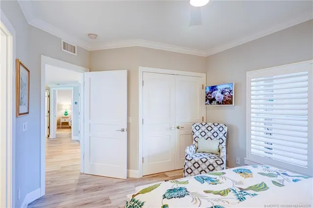 a bedroom with two beds and wooden floor