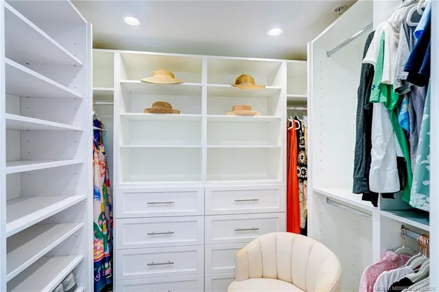 a view of a patio with table and chairs potted plants and floor to ceiling window