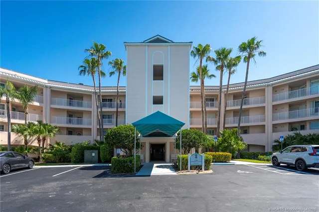 a living room with furniture a chandelier and a dining table