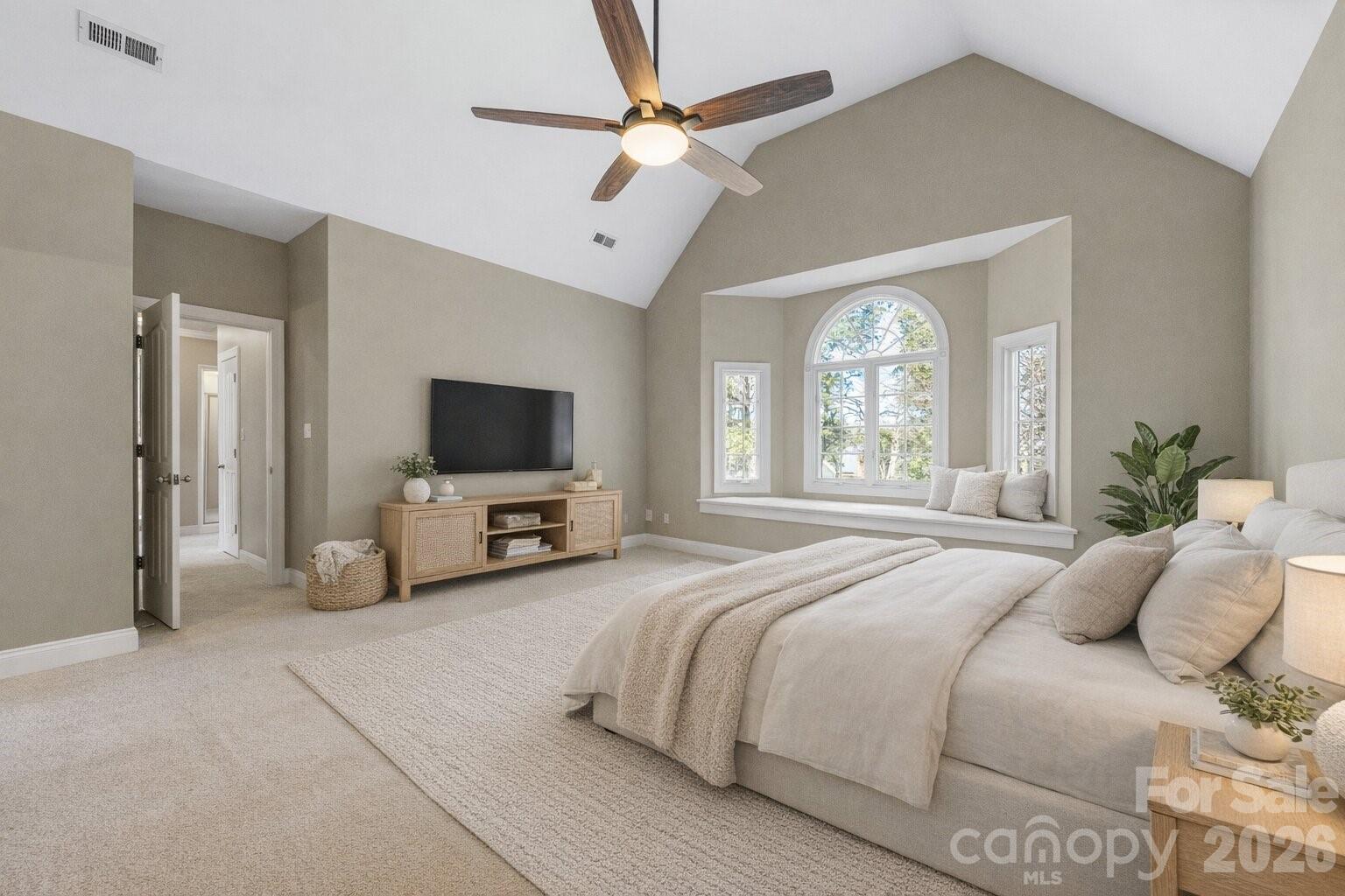 8380 Rocky River Road Harrisburg, NC 28075 - Photo 25 of 47 a spacious bedroom with a large bed a flat tv screen and a chandelier