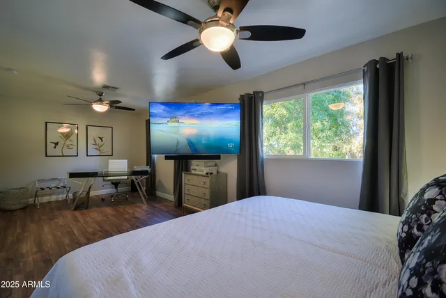 a bedroom with furniture and a flat screen tv