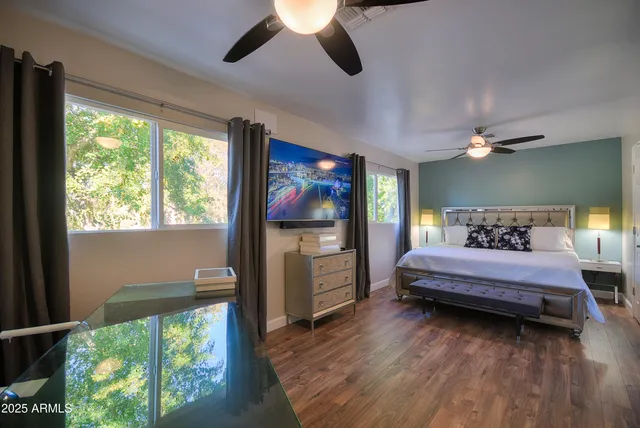 a bedroom with a bed and a flat tv screen on dresser