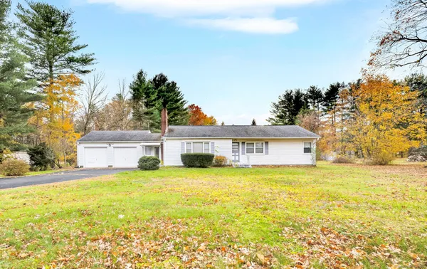 a view of a house with a yard and a large tree
