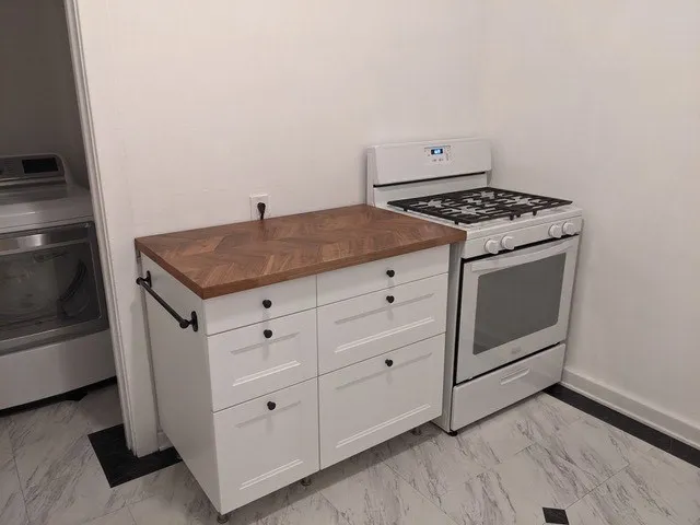 a kitchen with white cabinets and white appliances