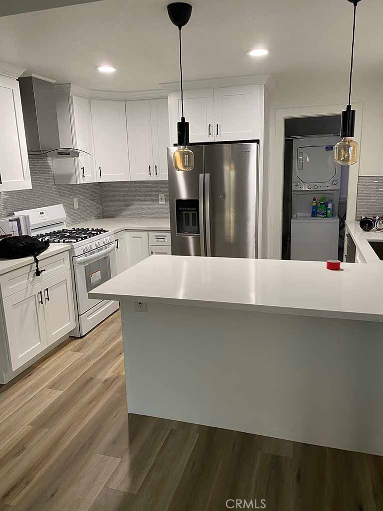 351 North Spaulding Avenue Los Angeles, CA 90036 - Photo 17 of 31 a large kitchen with stainless steel appliances a large counter top a stove a refrigerator white cabinets and wooden floor