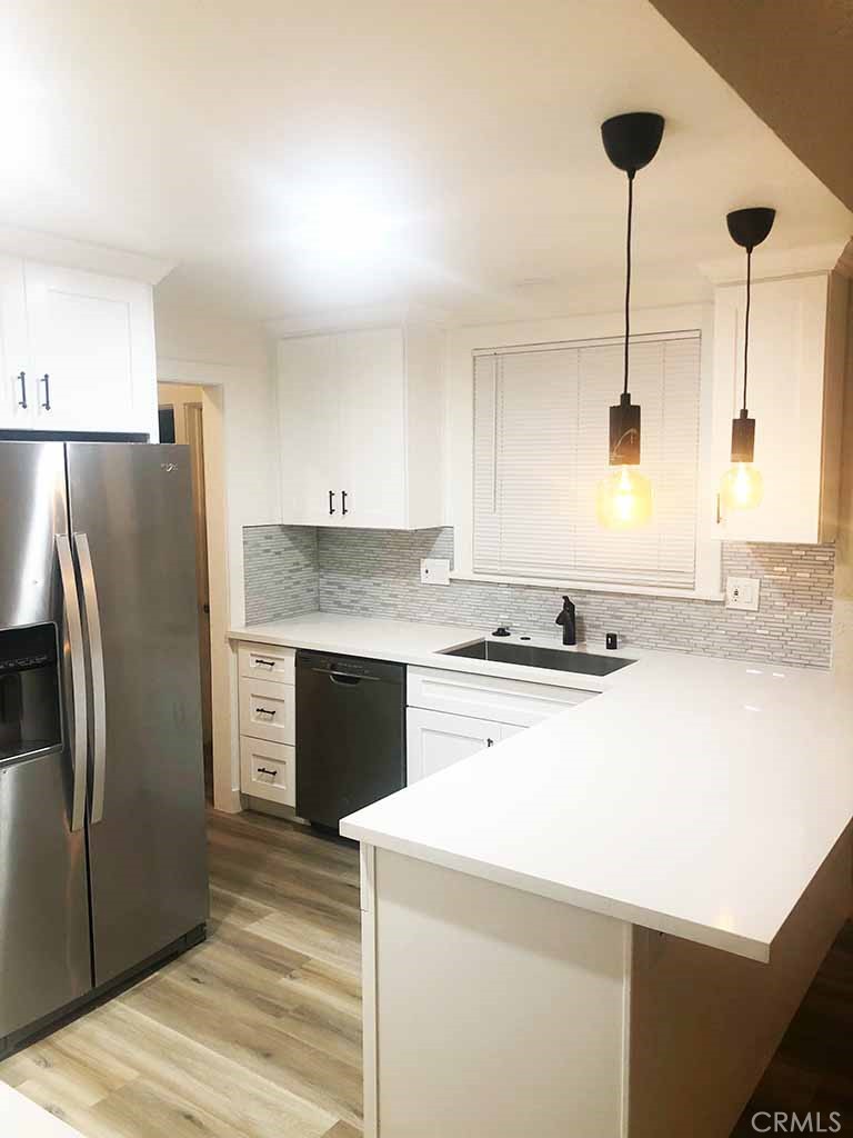 351 North Spaulding Avenue Los Angeles, CA 90036 - Photo 18 of 31 a kitchen with stainless steel appliances granite countertop a refrigerator a stove and a sink with wooden floor