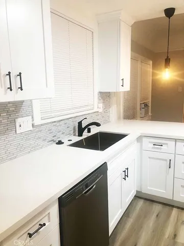 a kitchen with a sink dishwasher a stove and a refrigerator with wooden floor