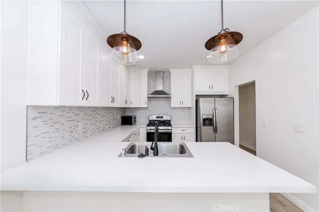 a kitchen with stainless steel appliances a stove a refrigerator and cabinets