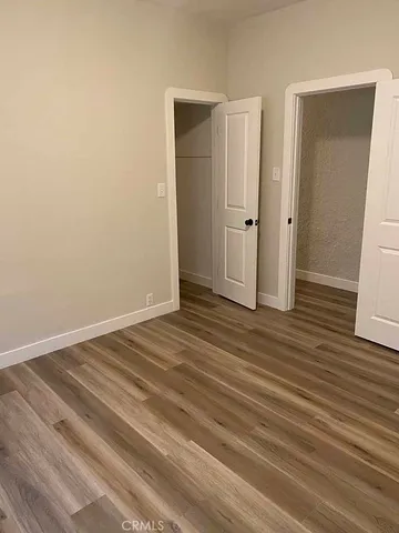 an empty room with wooden floor and closet