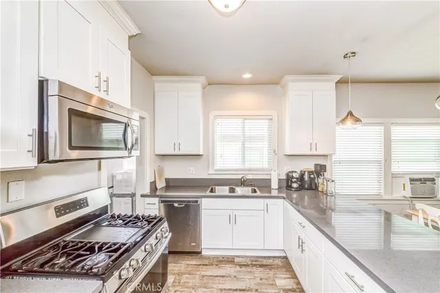 a kitchen with a sink stove top oven and cabinets