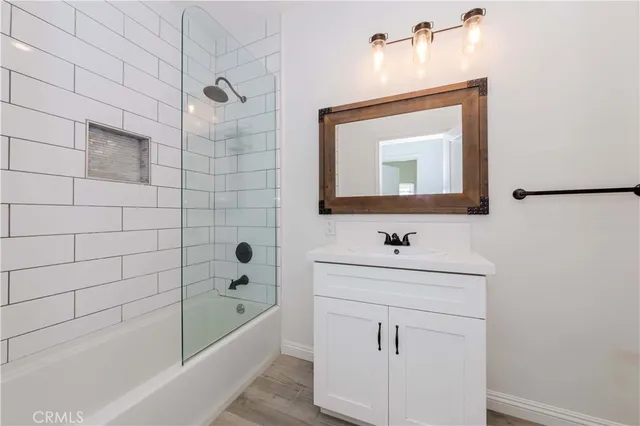 a bathroom with a sink a bathtub and a mirror