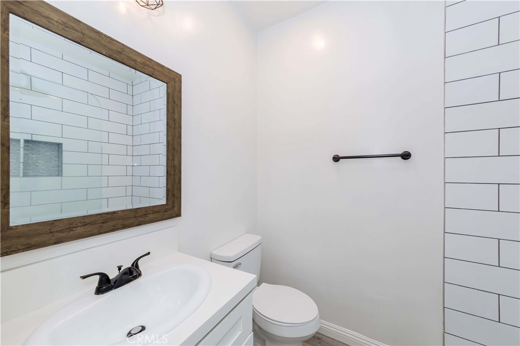 351 North Spaulding Avenue Los Angeles, CA 90036 - Photo 6 of 31 a bathroom with a sink a toilet and mirror