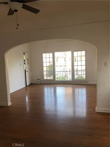 a view of a livingroom with wooden floor and a window