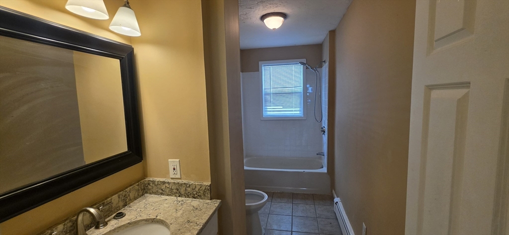 105 6th Street, Unit 1 Fall River, MA 02721 - Photo 6 of 8 a bathroom with a granite countertop sink and a mirror