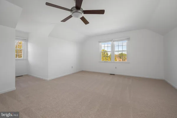 an empty room with a window and ceiling fan