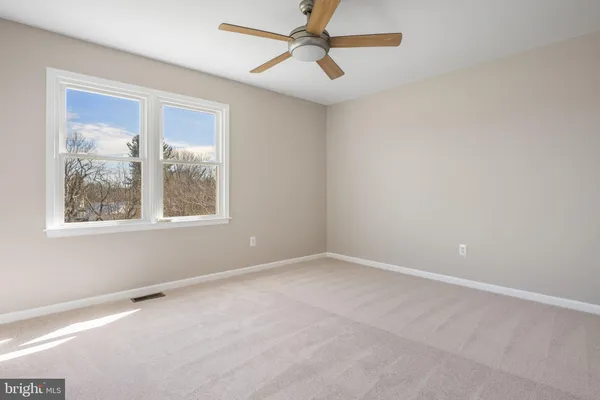 an empty room with a window and a fan