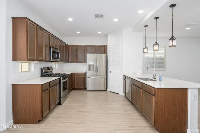 a kitchen with stainless steel appliances granite countertop a refrigerator stove a sink and a microwave