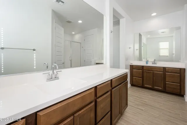 a bathroom with a double vanity sink a mirror and a shower