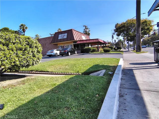 a car parked in front of a house with a big yard