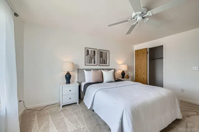 a bed room with a bed and a ceiling fan