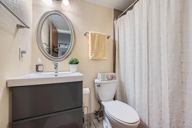 a bathroom with a toilet a sink and a mirror