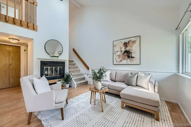 a living room with furniture a fireplace and a potted plant