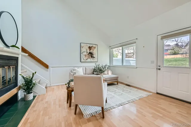 a living room with furniture floor to ceiling window and wooden floor