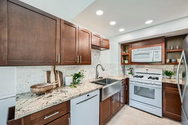 a kitchen with stainless steel appliances granite countertop a sink stove and cabinets