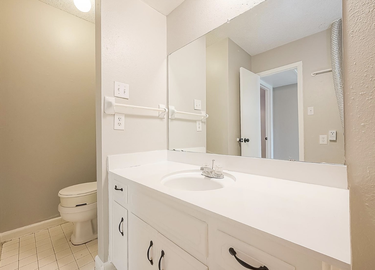 1108 West Tri Oaks Lane, Unit 150 Houston, TX 77043 - Photo 20 of 26 a bathroom with a sink a toilet and mirror