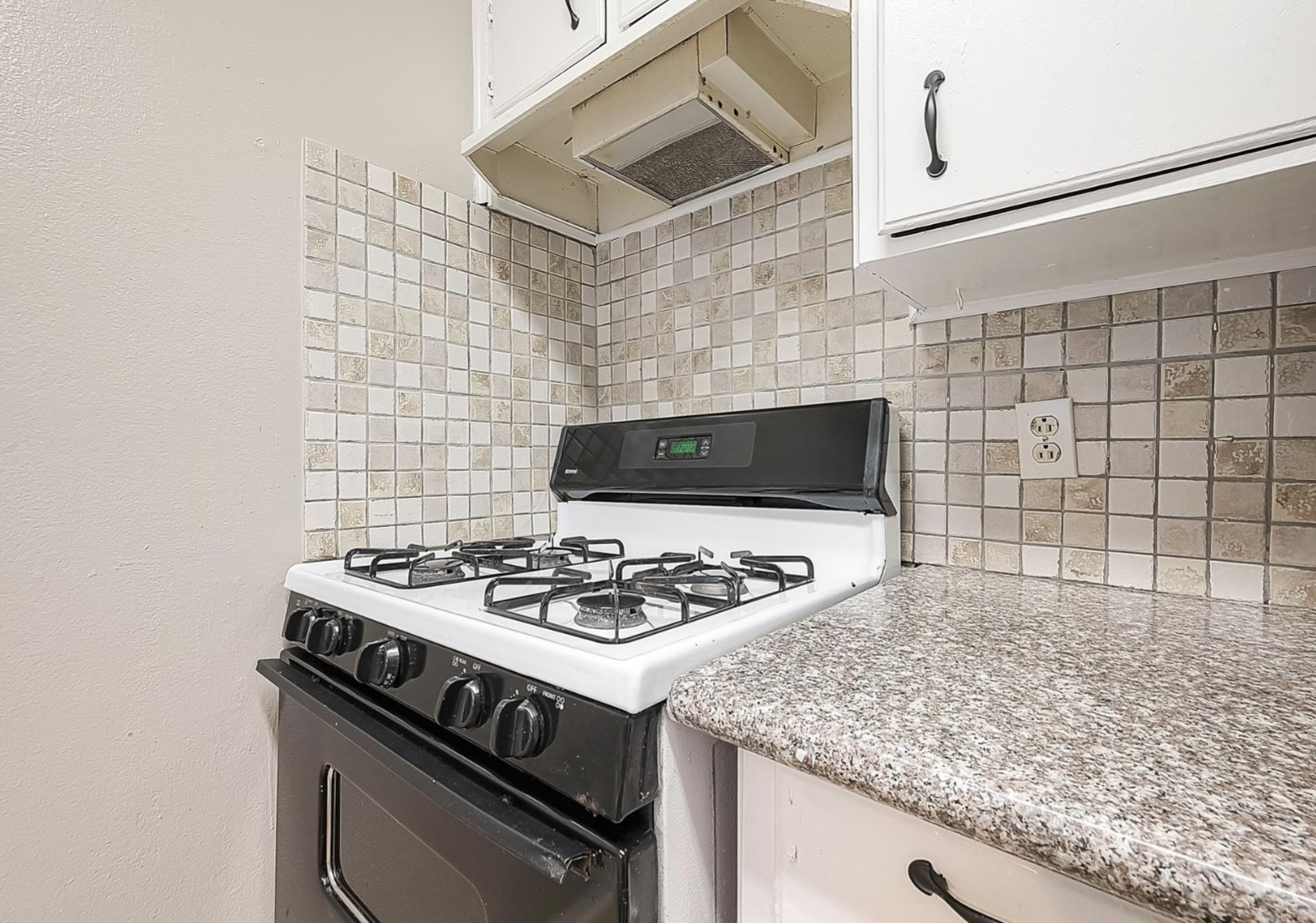 1108 West Tri Oaks Lane, Unit 150 Houston, TX 77043 - Photo 10 of 26 a stove top oven sitting inside of a kitchen