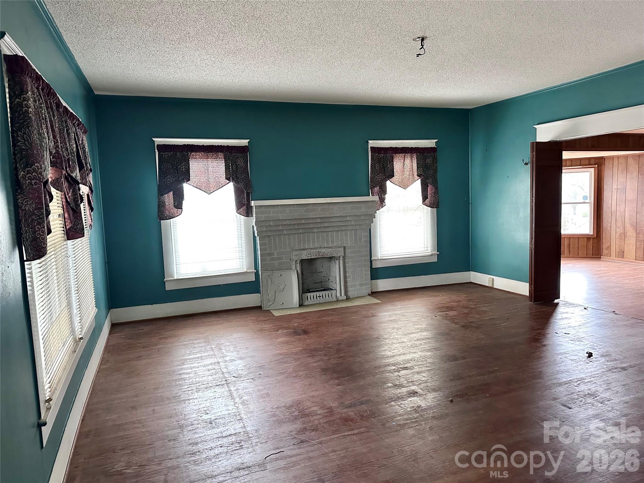 208 East Main Street Cleveland, NC 27013 - Photo 30 of 48 an empty room with wooden floor fireplace and windows