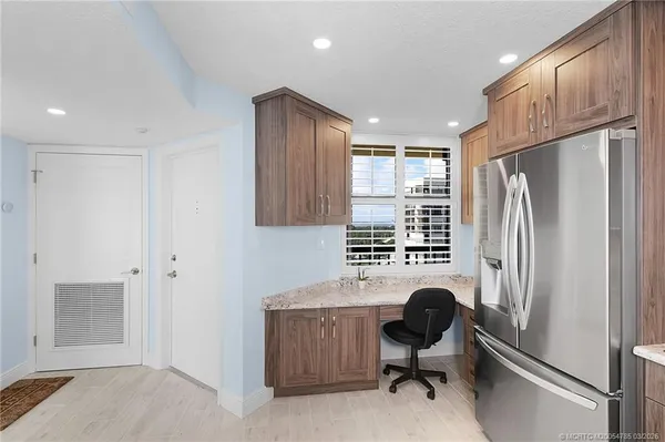 a large white kitchen with kitchen island granite countertop a counter space and stainless steel appliances