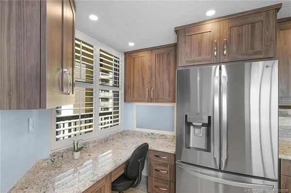 a kitchen with granite countertop a stove top oven and refrigerator