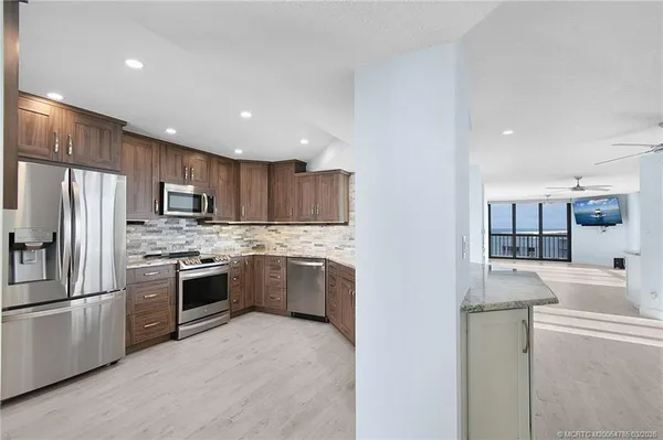 a kitchen with stainless steel appliances granite countertop a stove a sink and a microwave