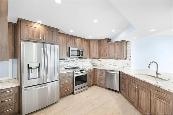a view of a kitchen with chair and refrigerator