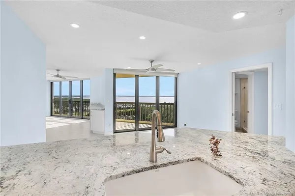 a view of kitchen with kitchen island stainless steel appliances a refrigerator and a stove top oven