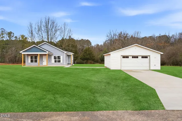 a view of house with garden and tall trees