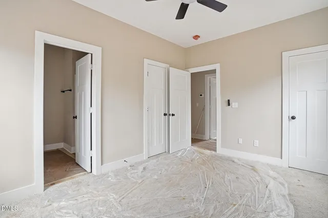 a view of a big room with closet and a chandelier fan