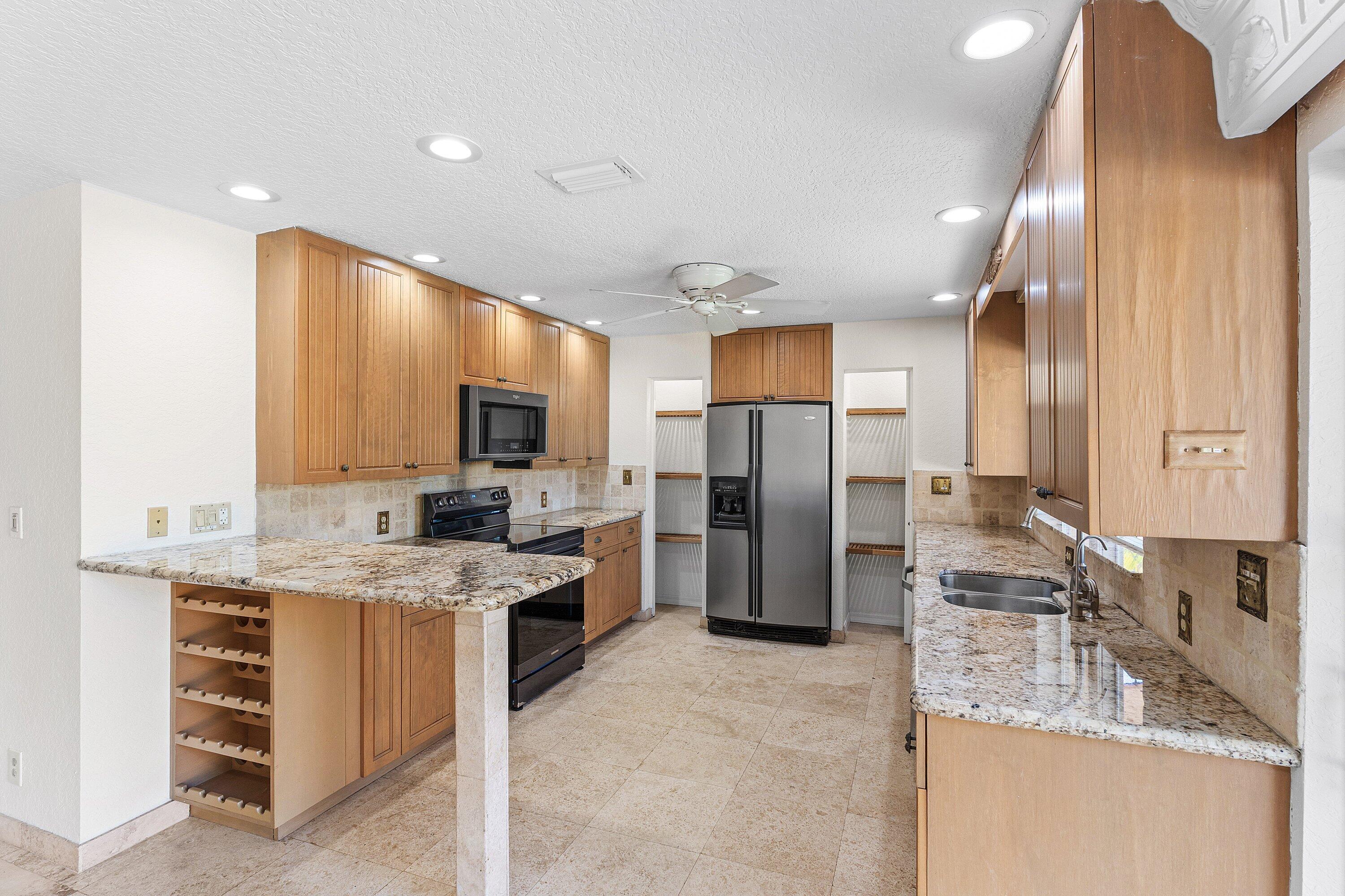 451 Northeast 25th Terrace Boca Raton, FL 33431 - Photo 14 of 47 a large kitchen with stainless steel appliances granite countertop a sink stove and refrigerator