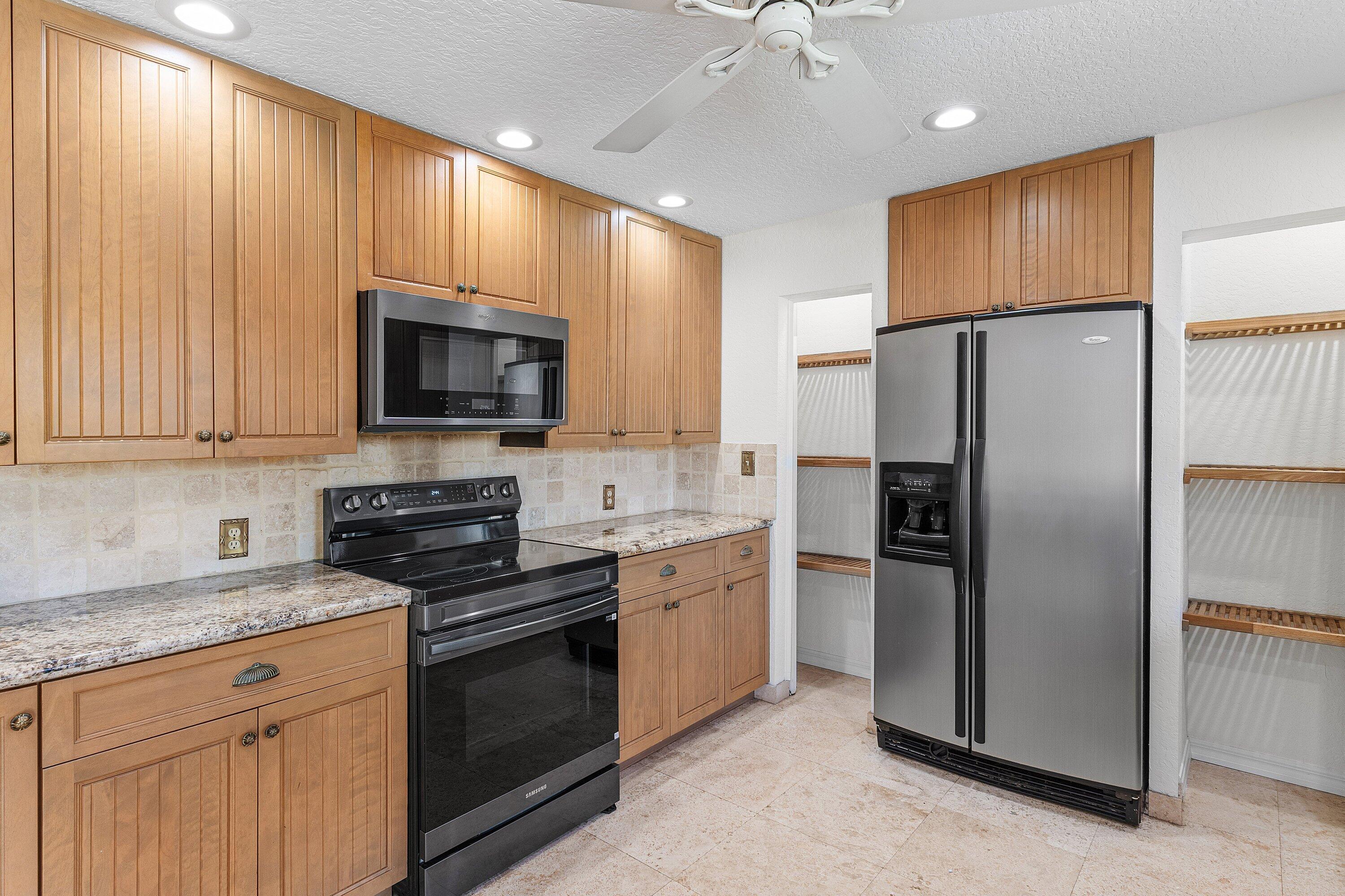 451 Northeast 25th Terrace Boca Raton, FL 33431 - Photo 15 of 47 a kitchen with stainless steel appliances granite countertop a refrigerator stove microwave and sink