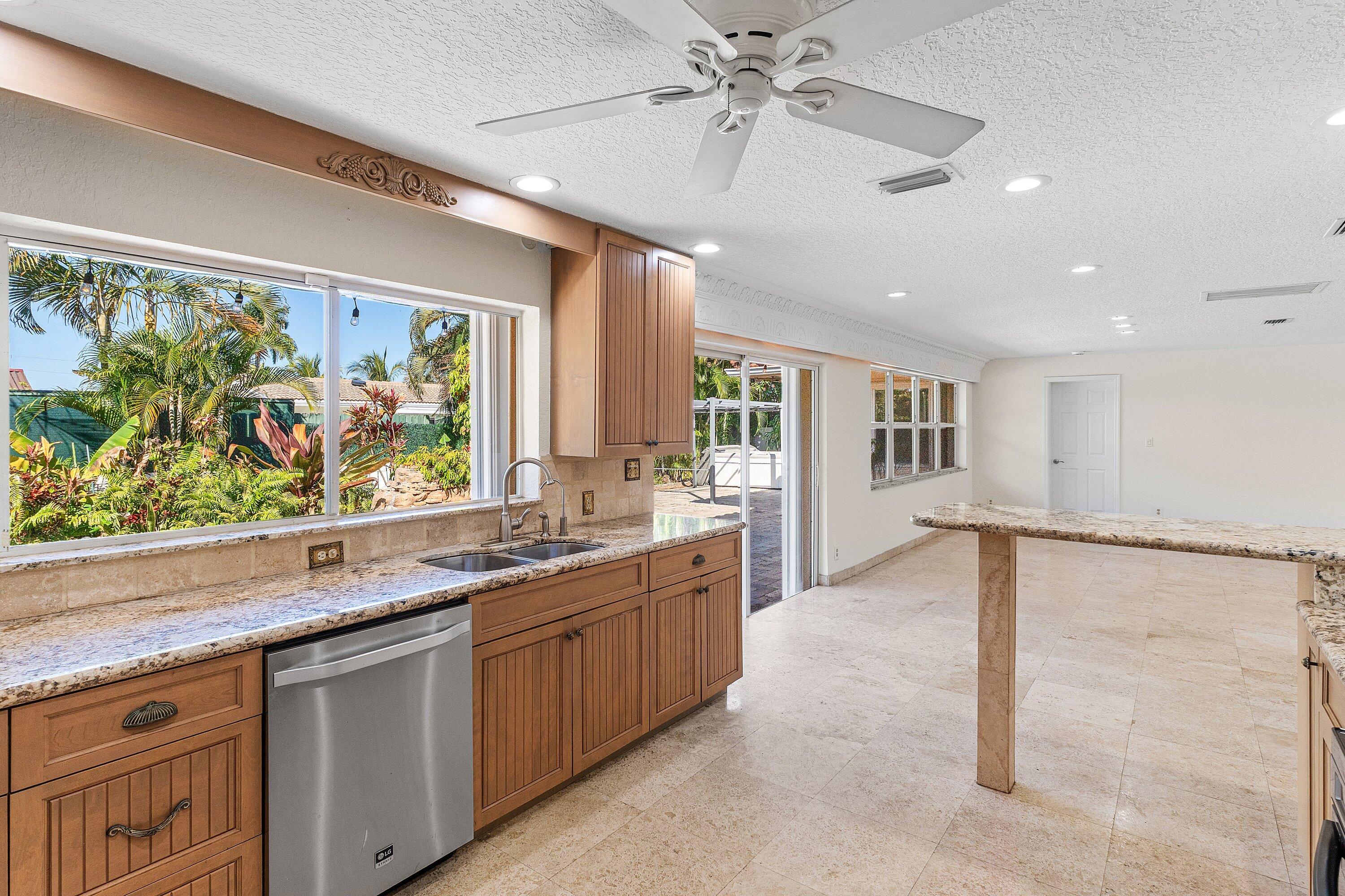 451 Northeast 25th Terrace Boca Raton, FL 33431 - Photo 17 of 47 a kitchen with stainless steel appliances granite countertop a sink and a counter top space