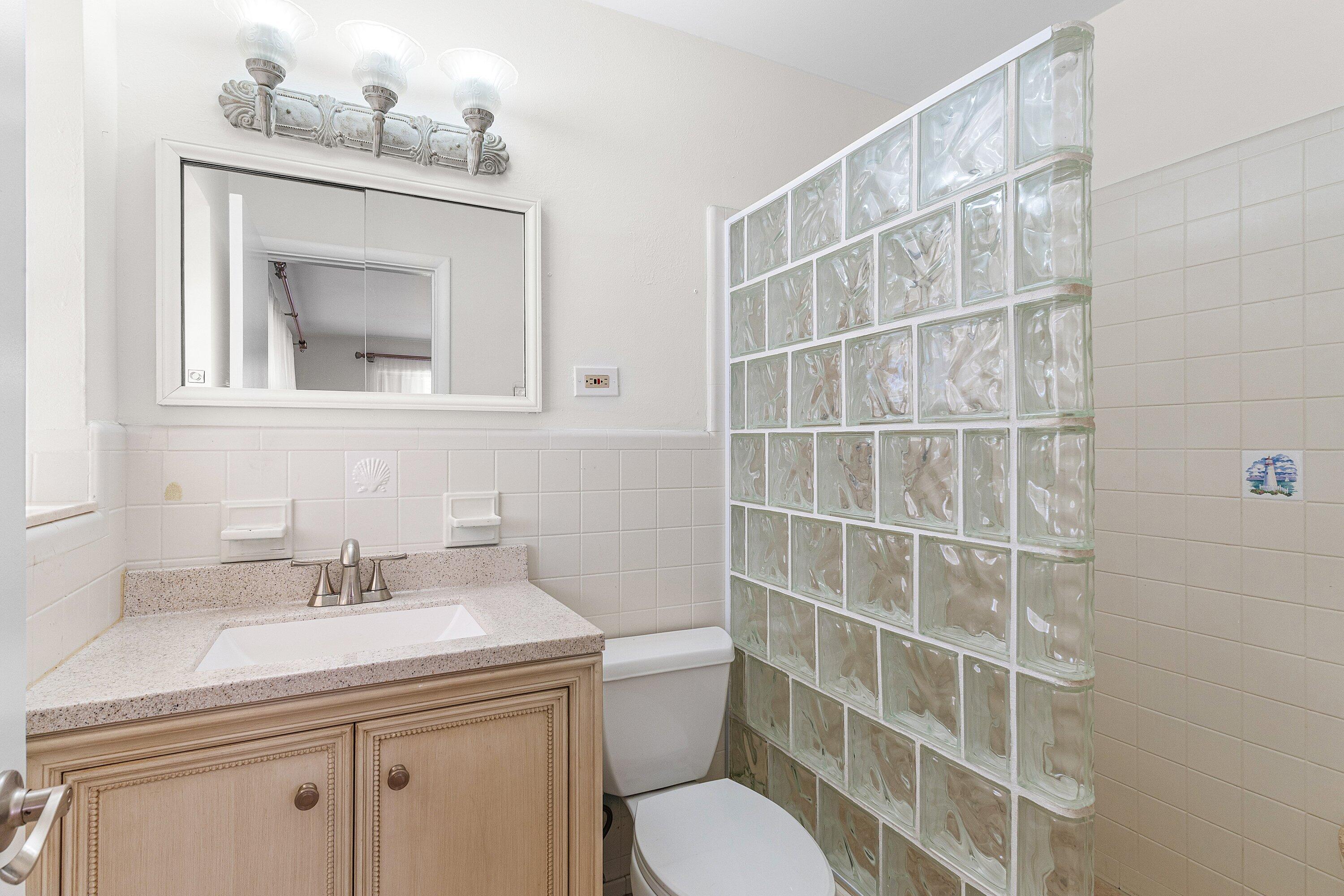 451 Northeast 25th Terrace Boca Raton, FL 33431 - Photo 21 of 47 a bathroom with a sink a toilet and a mirror