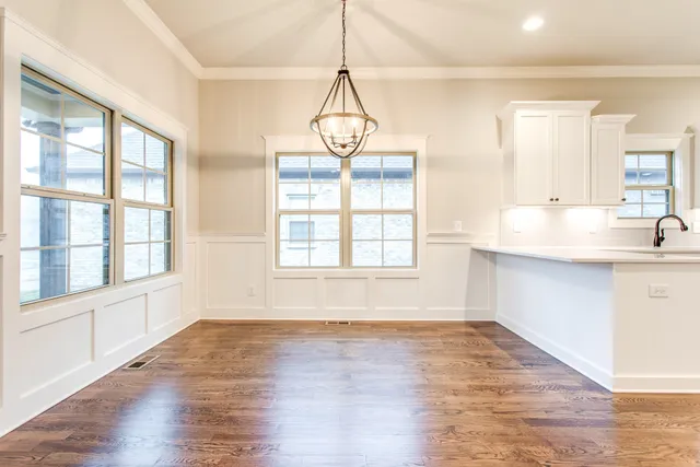 a view of a kitchen with wooden floor and a window