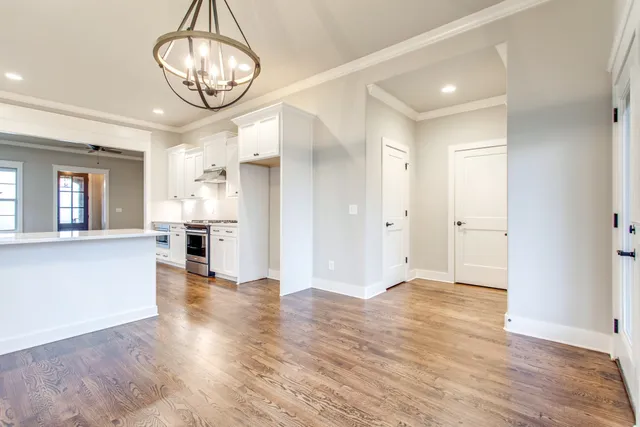 a view of empty room with wooden floor and window