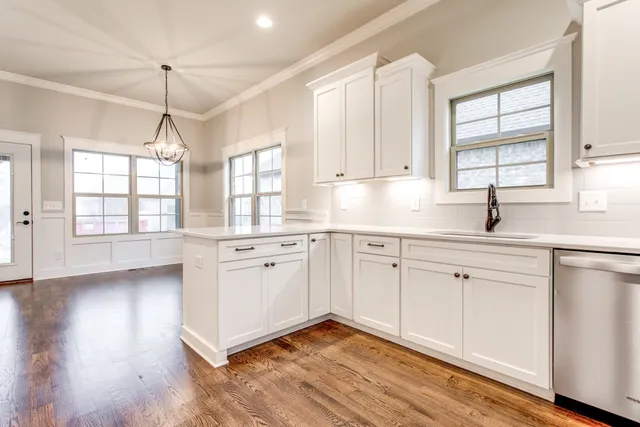 a kitchen with a window a sink and wooden floor