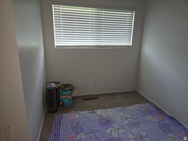 1273 North 400 East, Unit 4 Logan, UT 84341 - Photo 10 of 12 Room featuring neutral wall tones, window with horizontal blinds, and carpeted flooring