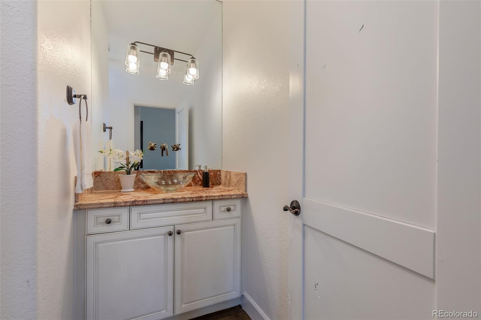 968 Summer Spring View Colorado Springs, CO 80906 - Photo 18 of 40 a bathroom with a granite countertop sink a toilet and a mirror