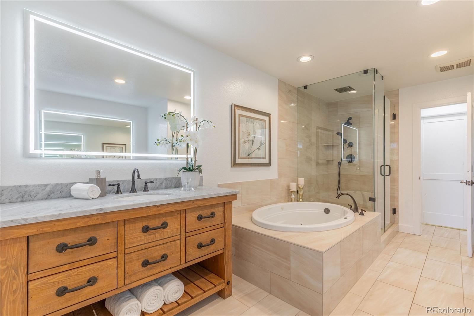 968 Summer Spring View Colorado Springs, CO 80906 - Photo 21 of 40 a bathroom with a sink double vanity granite tub shower and a mirror